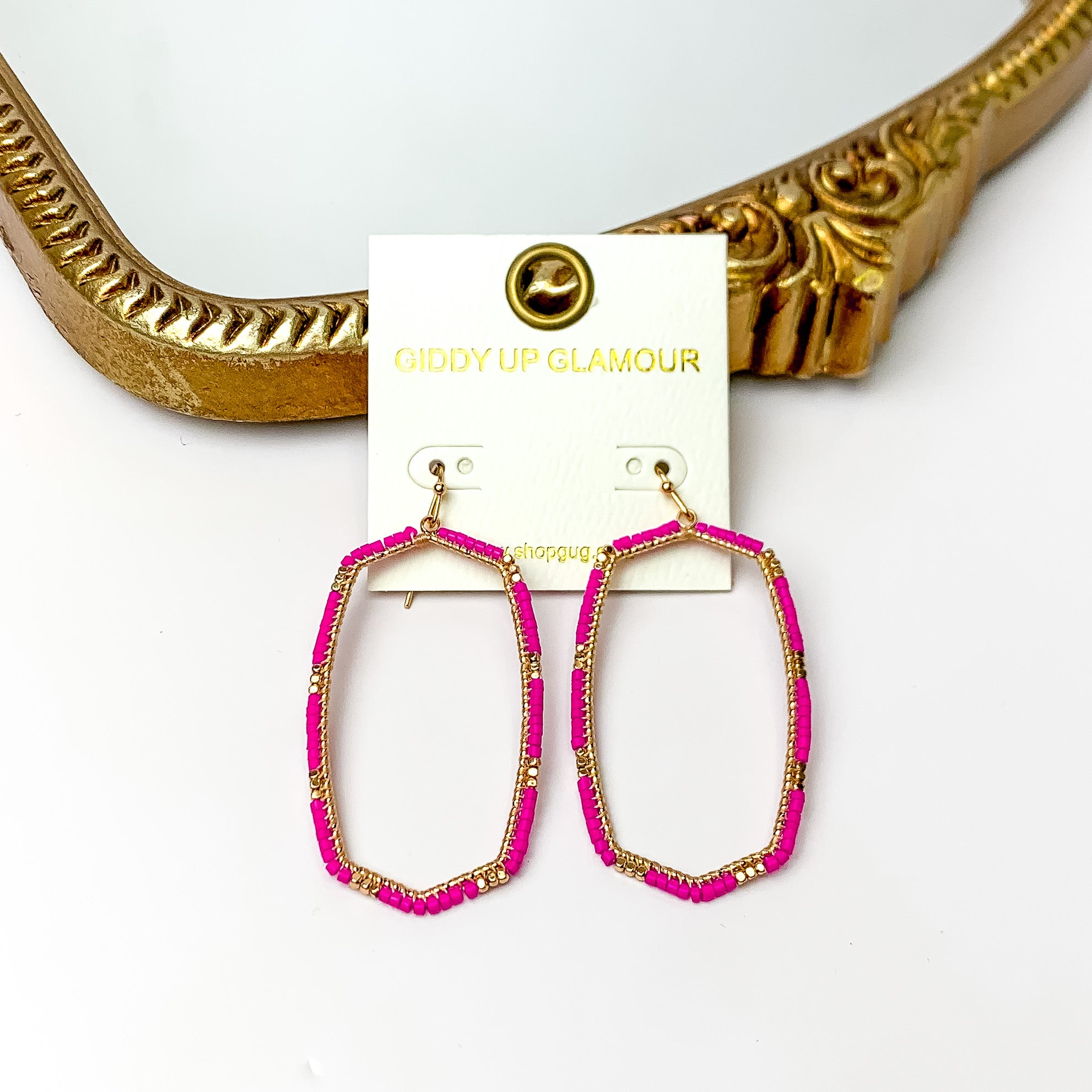 Hot Pink Beaded Open Large Drop Earrings with Gold Tone Accessory. Pictured on a white background with a gold frame through it.