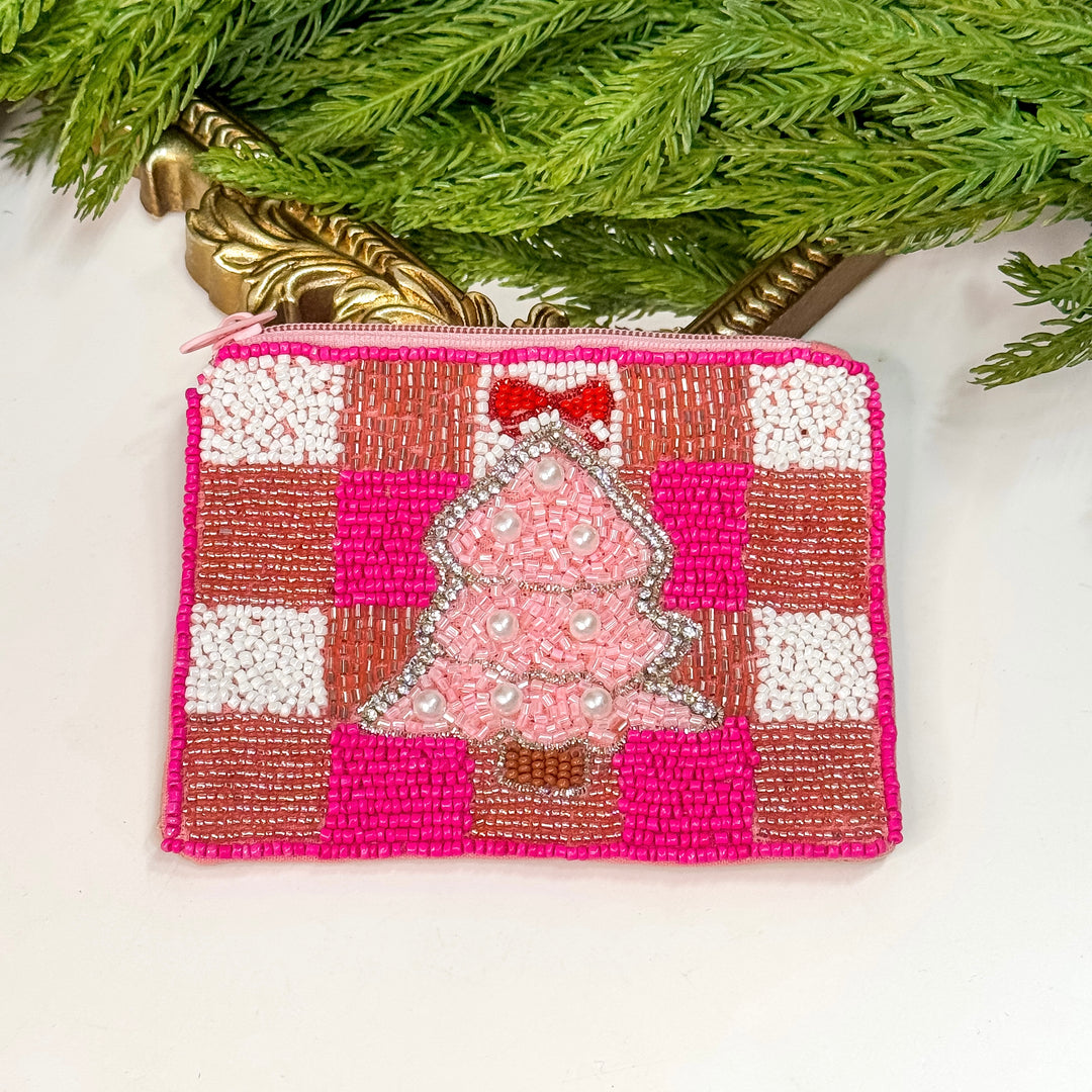 Beaded Christmas tree ornament on a pink and white checkered background with greenery in the background.