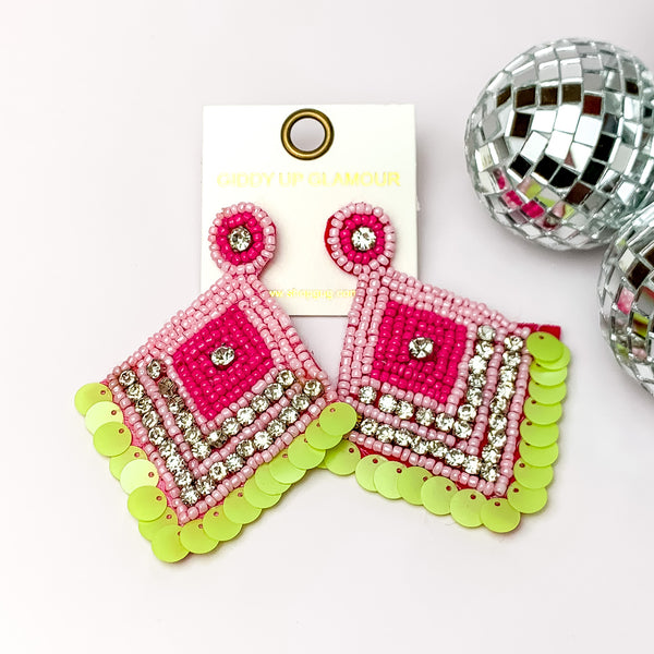 Fashionista Diamond Shaped Beaded Earrings in Pink, and Green. Pictured on a white background with disco balls on the right.