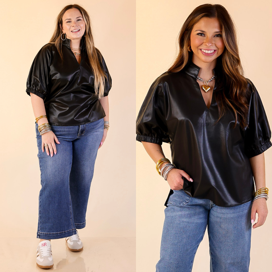 Two women wearing black faux leather balloon sleeve tops and blue jeans on a beige background