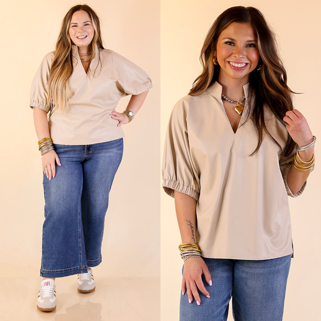 Two women wearing beige faux leather balloon sleeve tops and blue jeans on a beige background