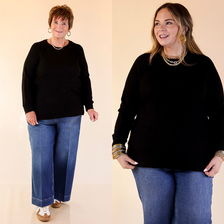 Two women wearing black tops and blue jeans on a beige background