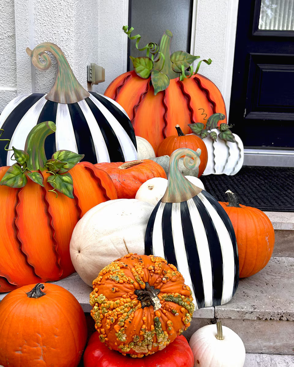Short and tall black and white striped pumpkins by The Round Top Collection styled with orange and white pumpkins for a layered fall front porch display.