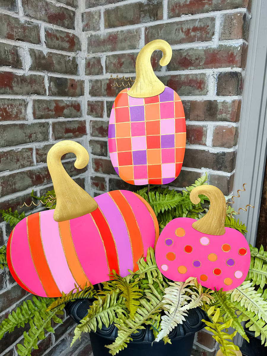 Bright checkerboard and polka dot pumpkin metal décor by The Round Top Collection in pink, orange, and lavender with gold glitter accents for colorful Halloween decorating.