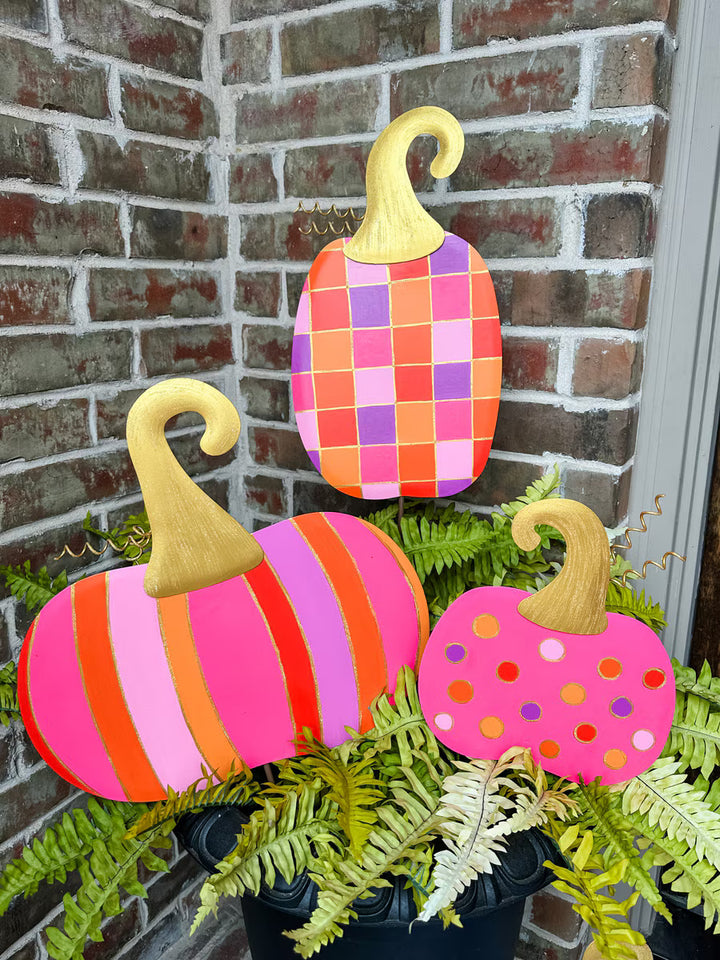 Bright checkerboard and polka dot pumpkin metal décor by The Round Top Collection in pink, orange, and lavender with gold glitter accents for colorful Halloween decorating.