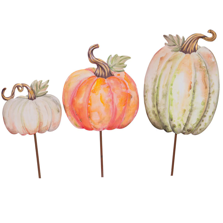 Three watercolor-style pumpkin garden stakes on a white background, shown in small, medium, and large sizes. The pumpkins have soft blended colors including orange, peach, cream, and pale green, with brown stems and leaves.
