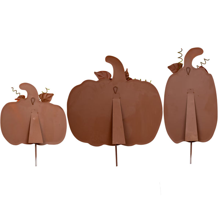 Three brown pumpkin decorations on sticks against a white background