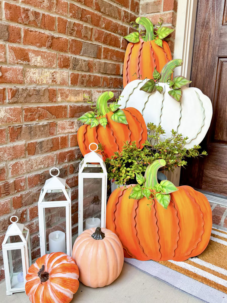 Decorative pumpkins and lanterns on a porch with a brick wall background