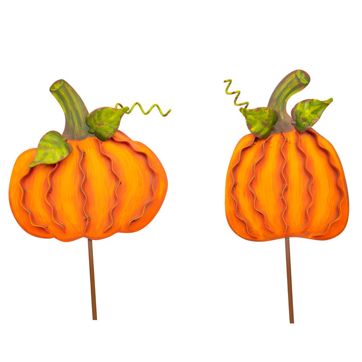 Two orange pumpkin garden stakes with green leaves and stems, shown side by side on a plain white background.