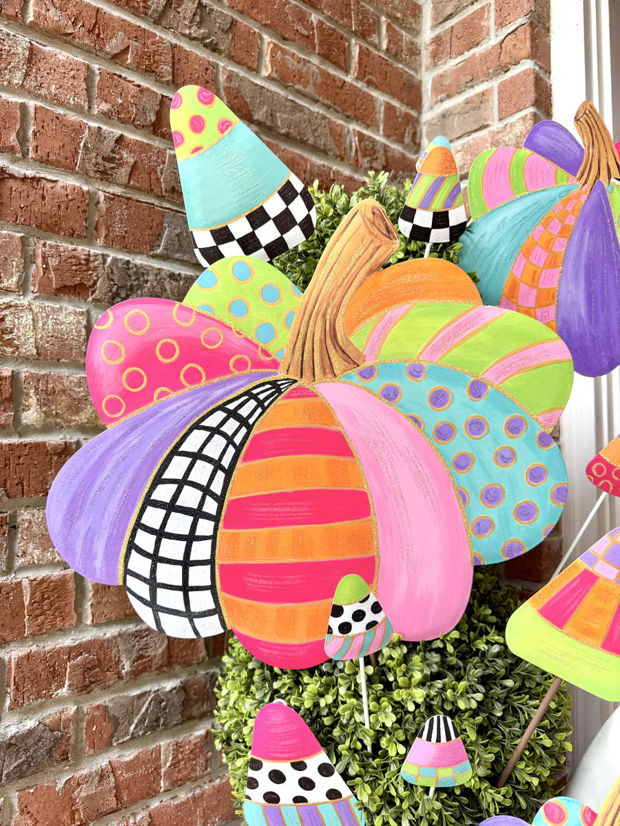 Colorful Party Pumpkin Short by The Round Top Collection styled in a planter with bright patterned fall and Halloween decorations.