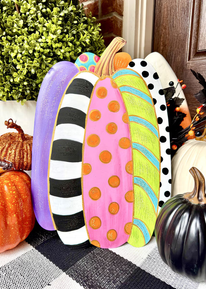 Colorful decorative pumpkins with polka dots and stripes on a festive background.