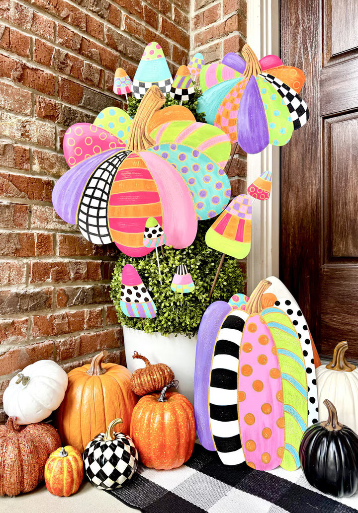 Bright colorful Party Pumpkin fall decorations by The Round Top Collection styled with candy corn stakes, pumpkins and greenery on a fall front porch.