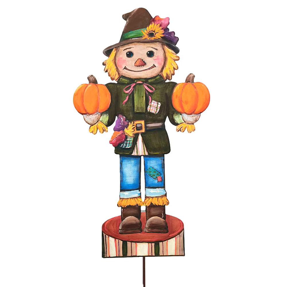 Large Scarecrow Nutcracker by Round Top Collection holding two orange pumpkins with green jacket, blue pants, fall hat and striped base.