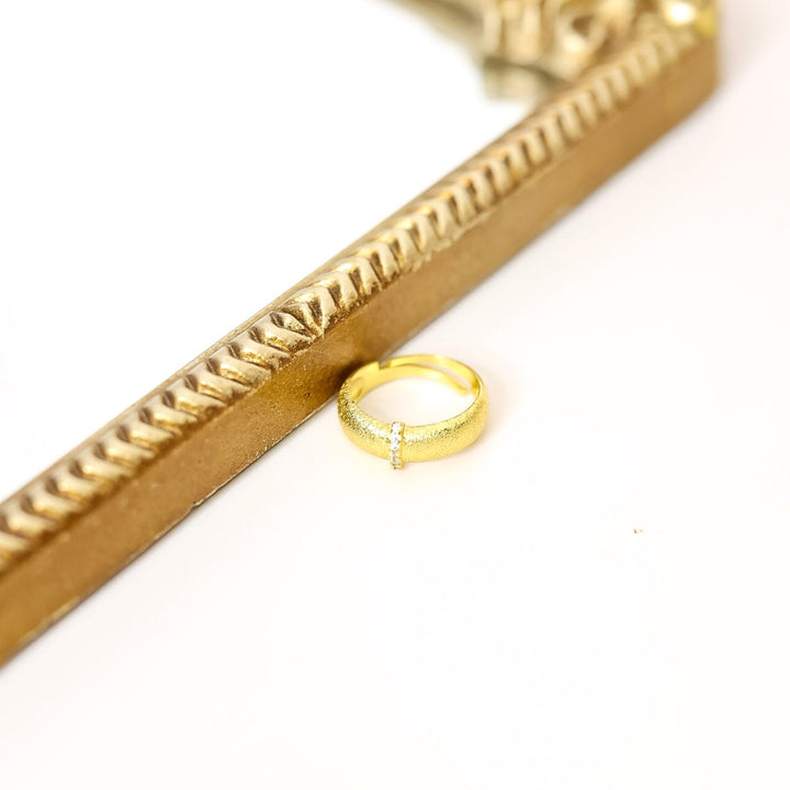 Gold ring on a gold chain with a white background