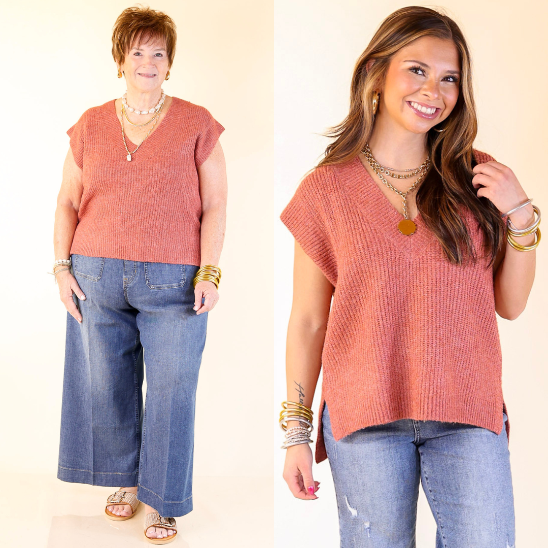 Two women wearing a rust orange sleeveless top and blue jeans on a plain background