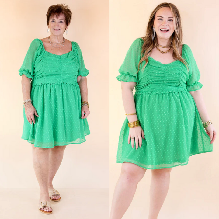 This dress includes a ruched bodice, short balloon sleeves, and a zip up back. Available in sizes small through plus size.