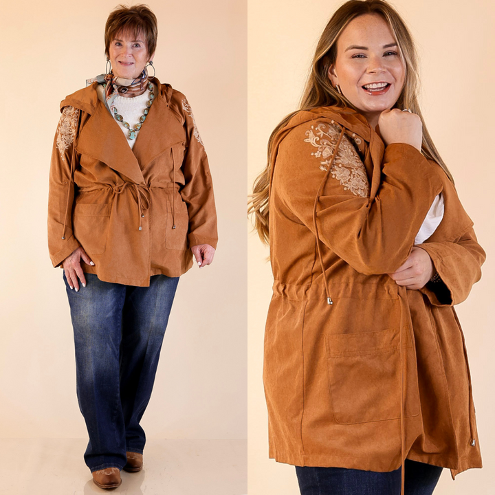 Two people wearing tan suede utility jackets with embroidered details on a beige background