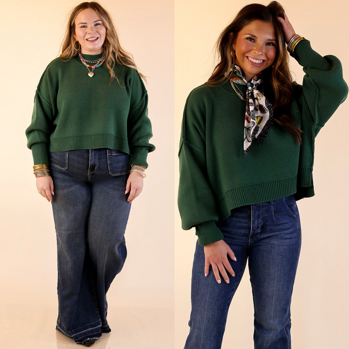 Two models wearing the Forest Green 'Fireside Fit' cropped long sleeve mock neck sweater with jeans. Against a plain background.