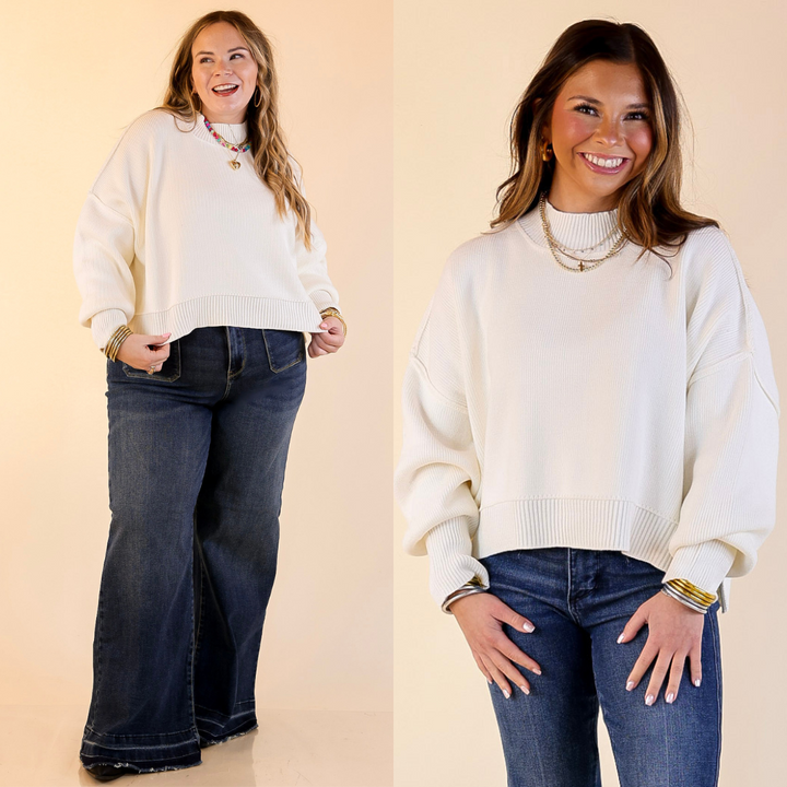 Two models wearing the Ivory 'Fireside Fit' cropped long sleeve mock neck sweater with jeans. Against a plain background.