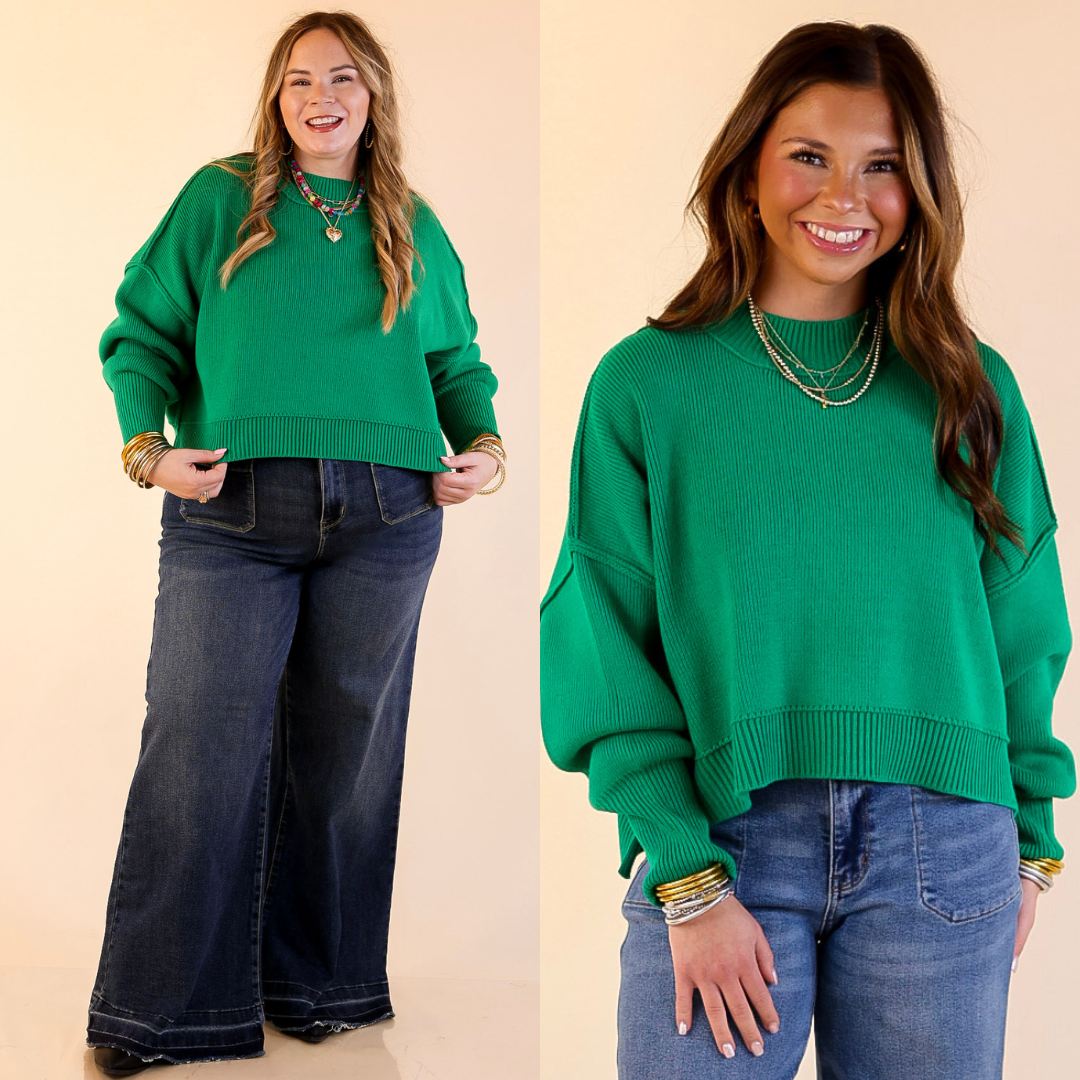 Two models wearing the Kelly Green 'Fireside Fit' cropped long sleeve mock neck sweater with jeans. Against a plain background.