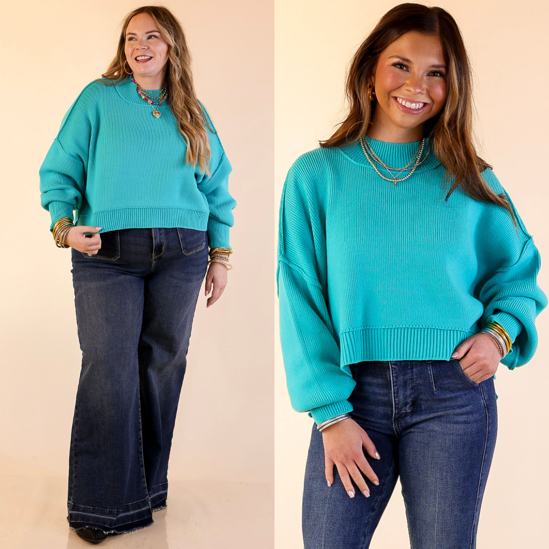 Two models wearing the Turquoise Blue 'Fireside Fit' cropped long sleeve mock neck sweater with jeans. Against a plain background.