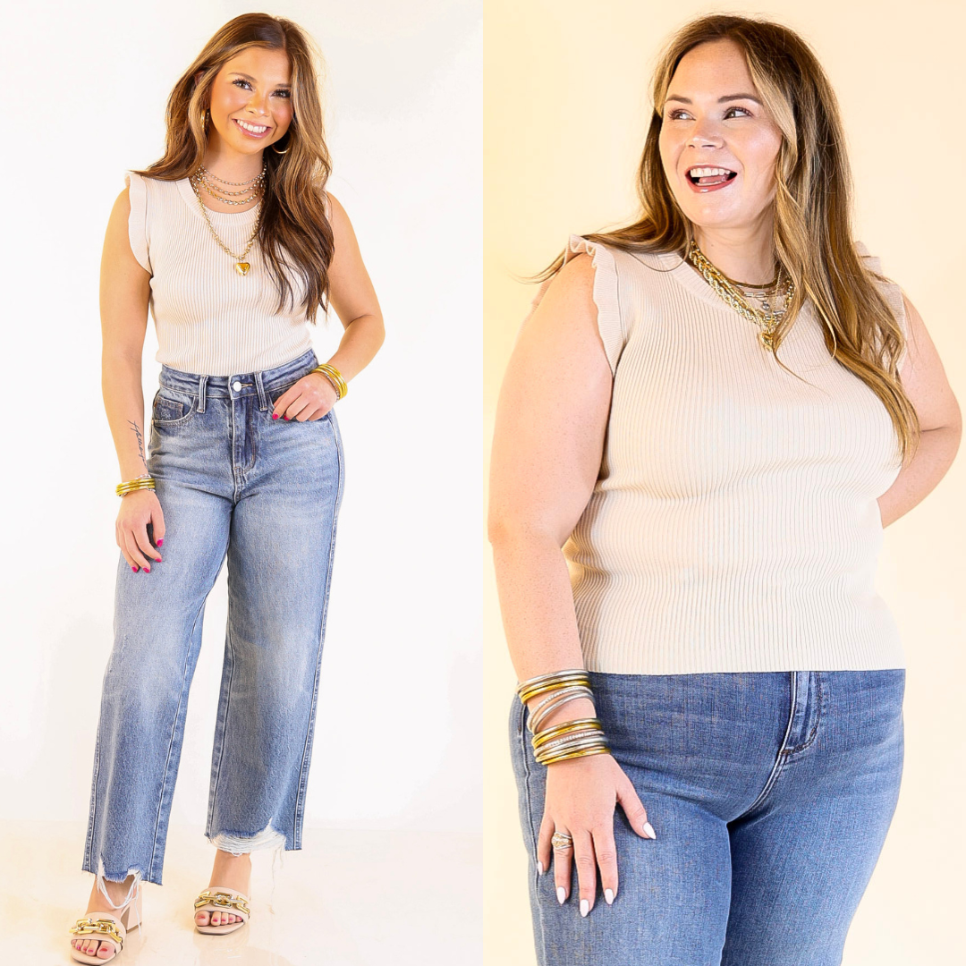 Two women wearing ivory ruffle sleeve tops and jeans against a plain background