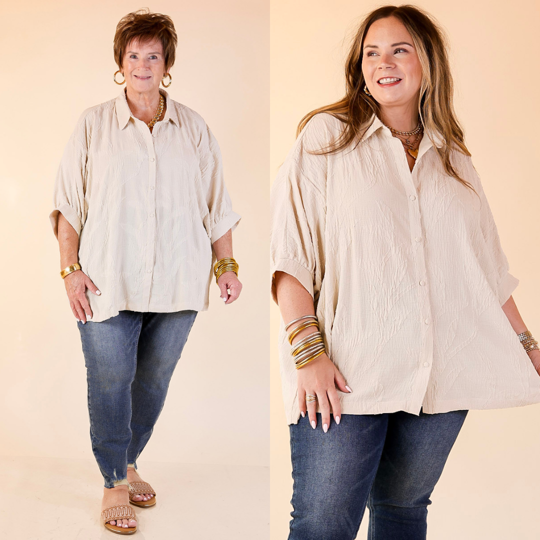 Two women wearing beige shirts and blue jeans against a beige background