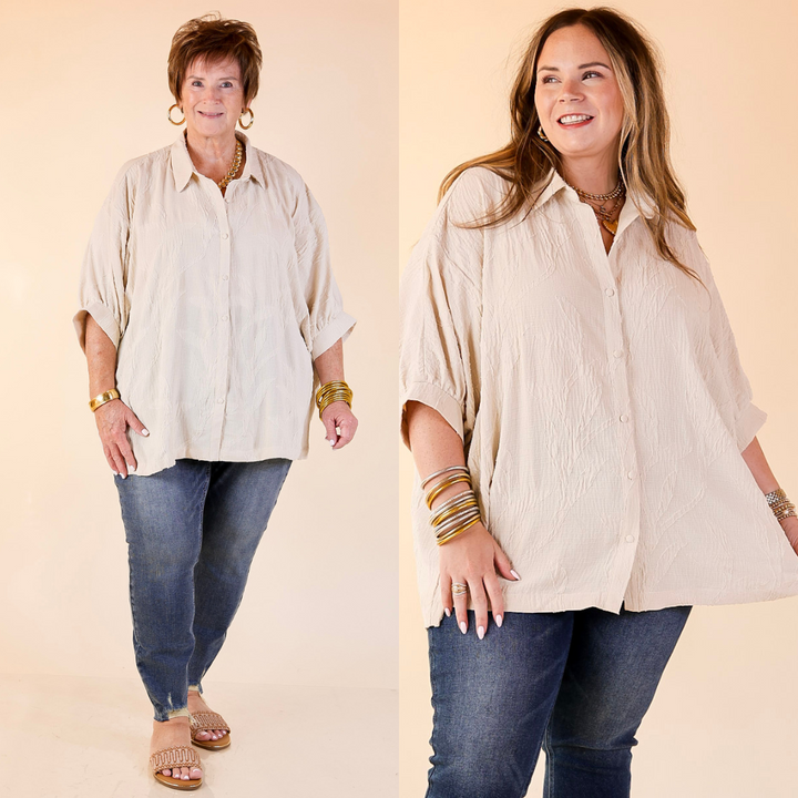 Two women wearing beige shirts and blue jeans against a beige background