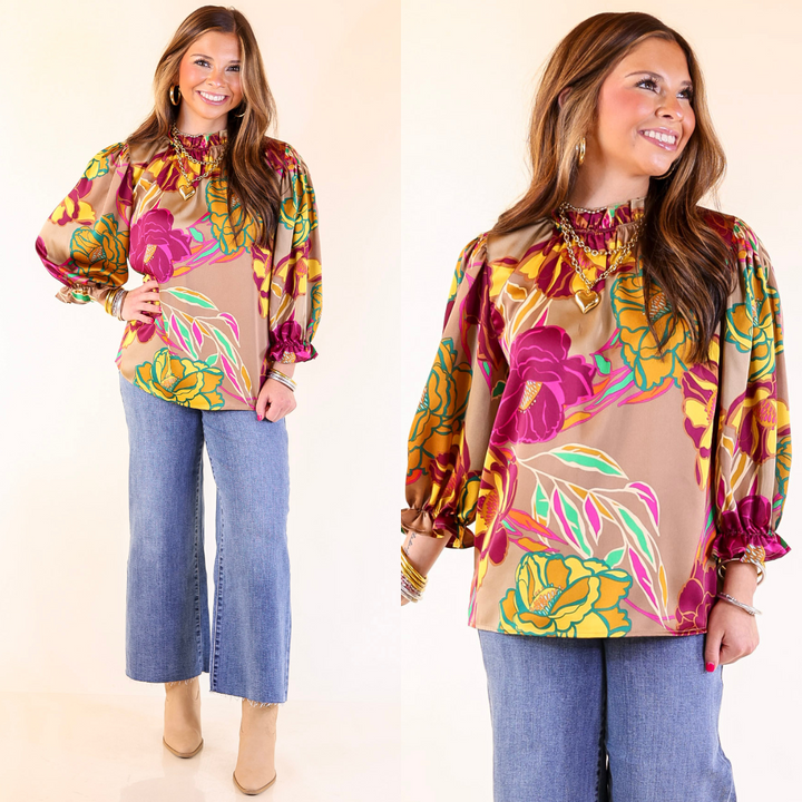 A woman wearing a Mocha floral blouse and jeans with a beige background