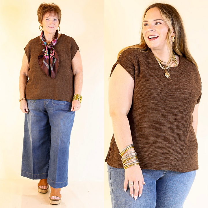 Two women wearing brown sweater vest tops and blue jeans against a plain background