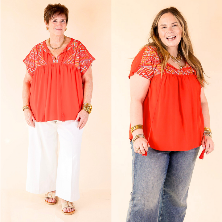 This top includes short sleeves, an embroidered upper, a front keyhole with a tie, and a bright material. Available in sizes small through plus size.