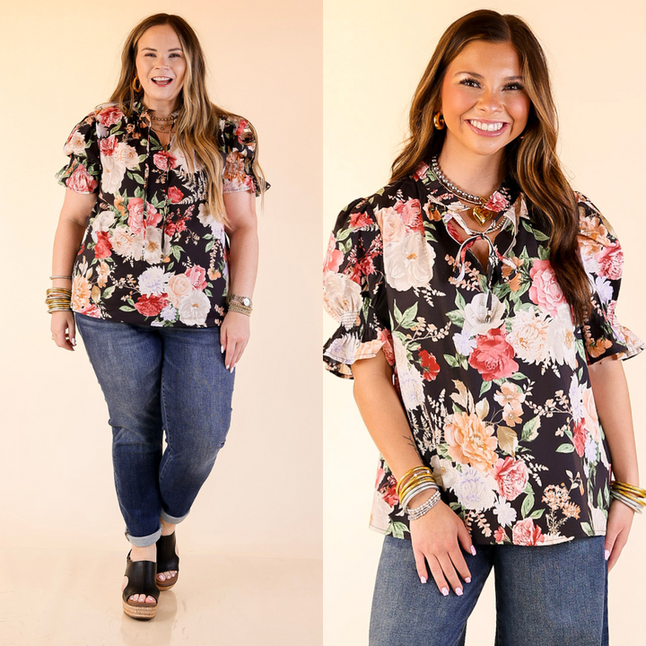 Models wearing floral print top with short puff sleeves in black against a plain background. 