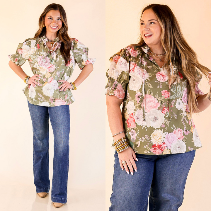 Models wearing floral print top with short puff sleeves in olive green against a plain background. 