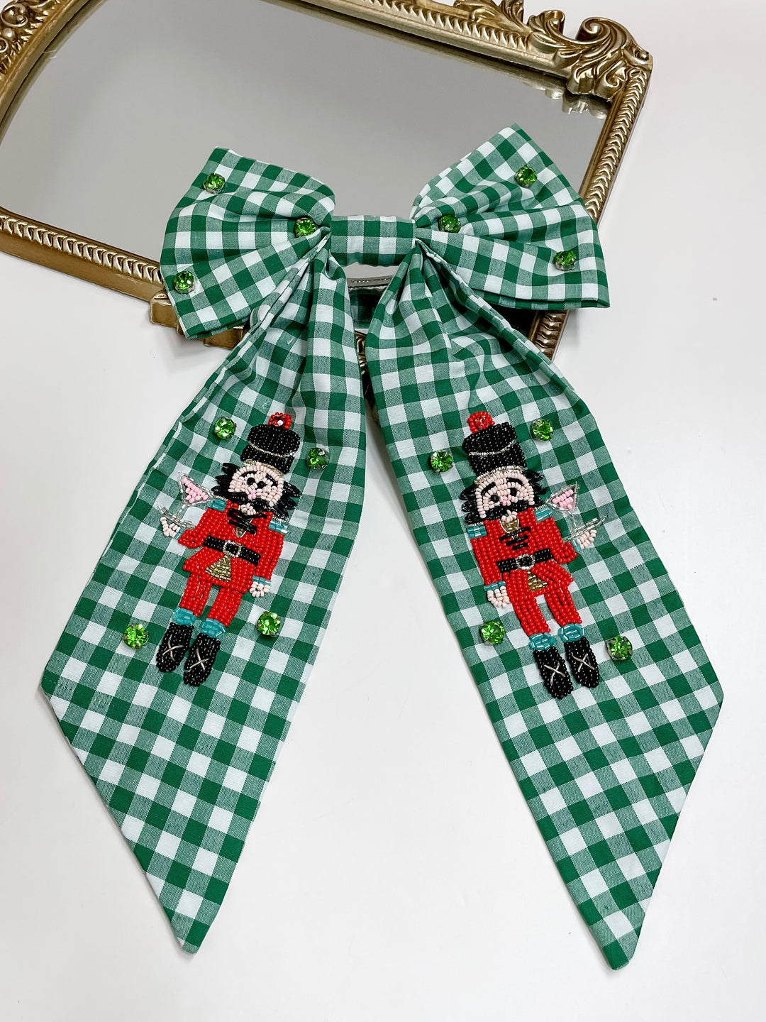 Green gingham Christmas hair bow with hand-beaded nutcrackers and green crystals, festive holiday accessory.