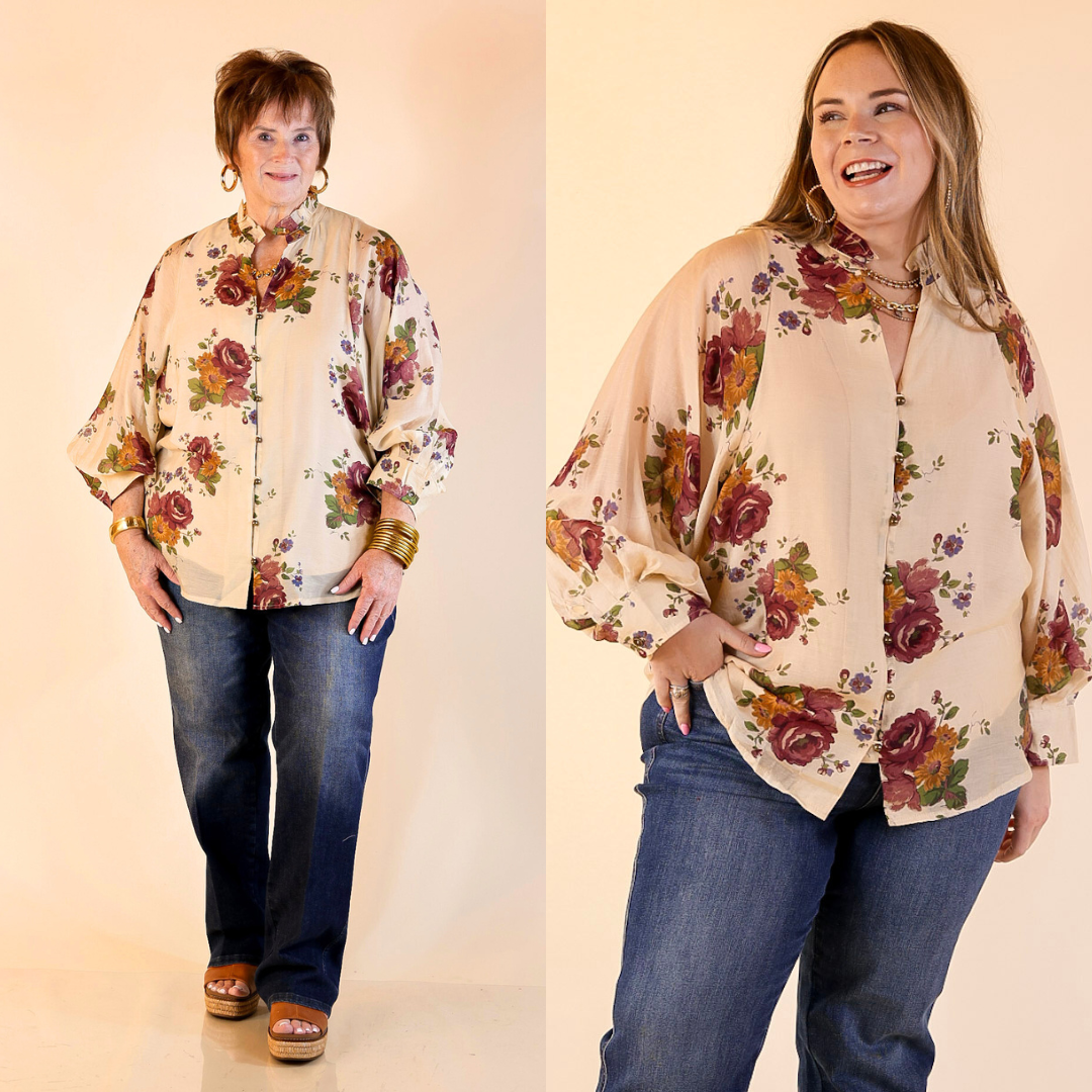 Two women wearing floral blouse in cream and jeans on a plain background