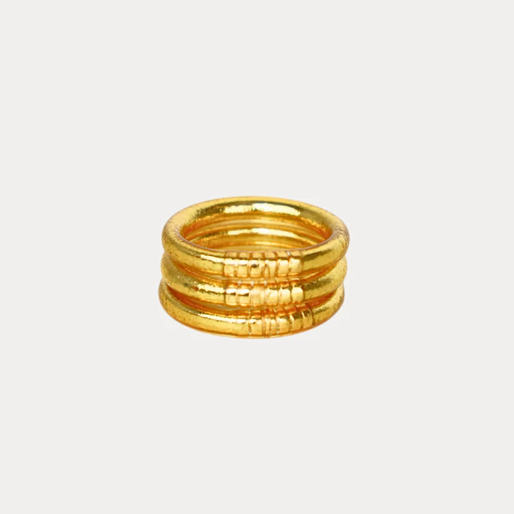 Set of gold rings stacked on a light gray background