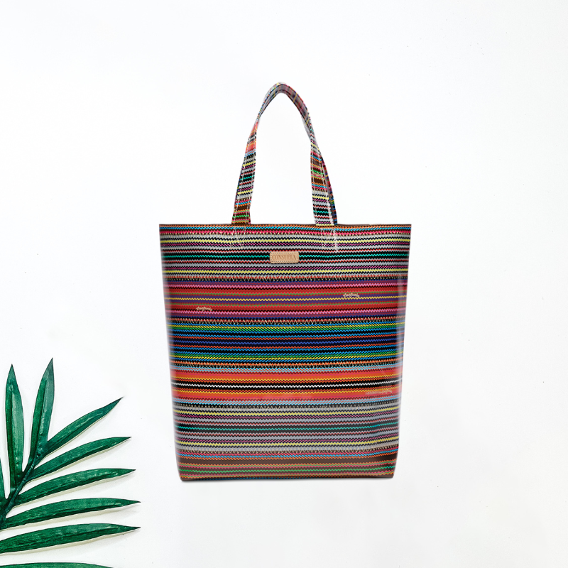 Multicolored striped tote bag on a white background with a green leaf