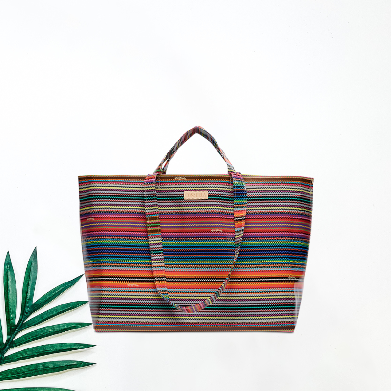 Multicolored striped tote bag on a white background with a green leaf