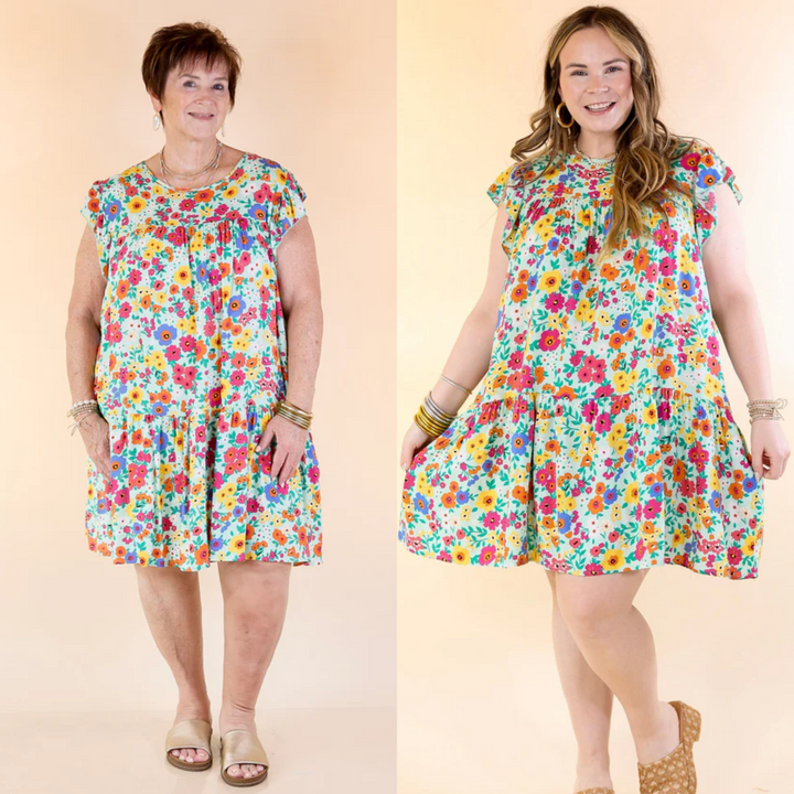 This dress features a mint green color with a beautiful floral print, ruffle cap sleeves, and a tiered body. Available in sizes small through plus size.