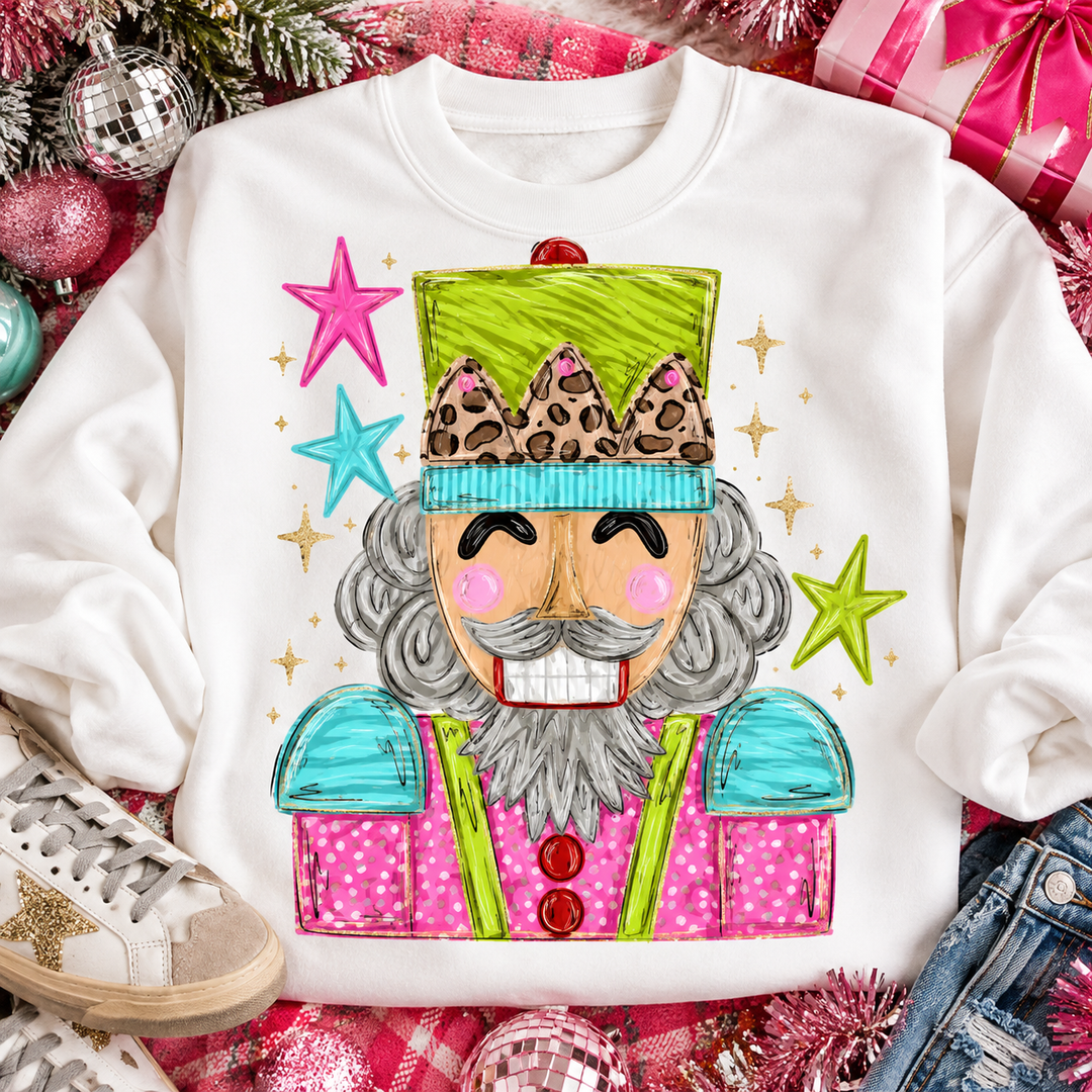 Hand Drawn Preppy Nutcracker Christmas graphic tee or sweatshirt on white with a hand-drawn nutcracker in neon green, turquoise and pink with stars