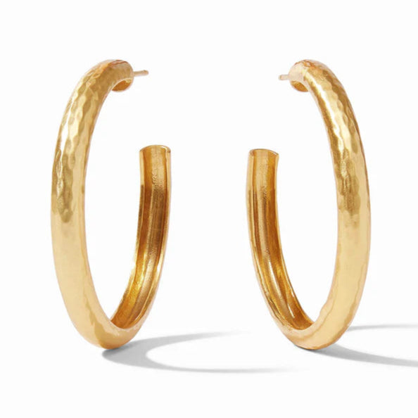 Pictured is a pair of gold, hammered earrings on a white background. 