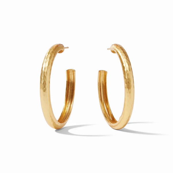 Pictured is a pair of gold, hammered earrings on a white background. 