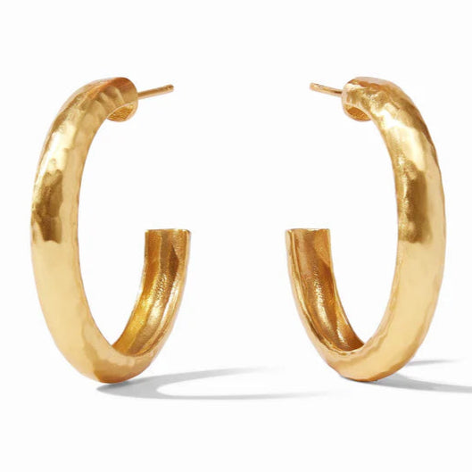 Pictured is a pair of gold, hammered earrings on a white background. 