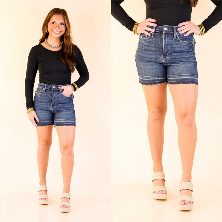 The Highest Honor shorts feature a high-waisted, tummy control fit with a dark wash and distressed release hem for a sleek, edgy look.