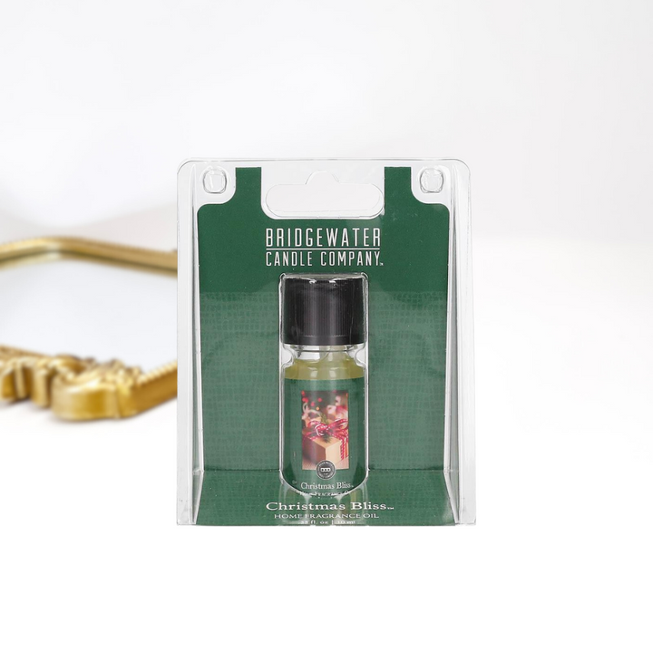 A solid white background with a gold mirror and a home fragrance oil by bridgewater candle company.