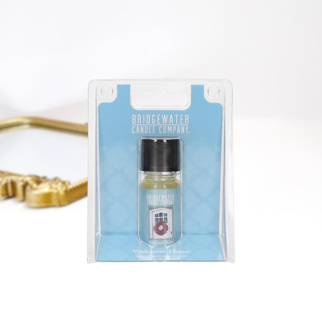 A solid white background with a gold mirror and a home fragrance oil by bridgewater candle company.