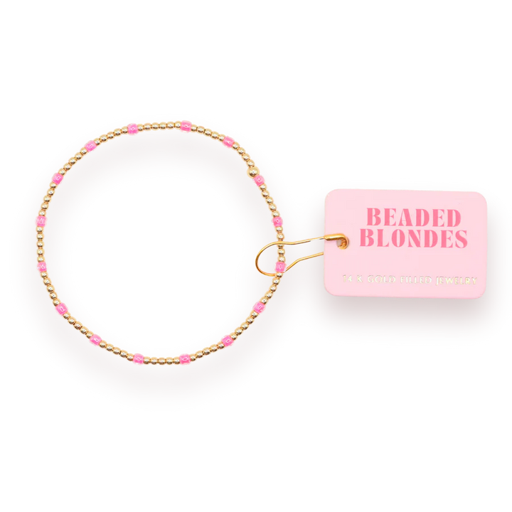 Add a bold pop of color to your stack with the Hot Pink Dainty Poppi Bracelet, a perfect blend of elegance and fun. This bracelet features a mix of 2mm and small Czech glass beads in vibrant hot pink, paired with 14K gold-filled detailing for a touch of luxury.

Carefully hand-strung in College Station, Texas by the talented Beaded Blondes duo, this bracelet is designed to keep up with your busy lifestyle. It's water-resistant, workout-proof, and tarnish-proof, making it perfect for everyday wear.