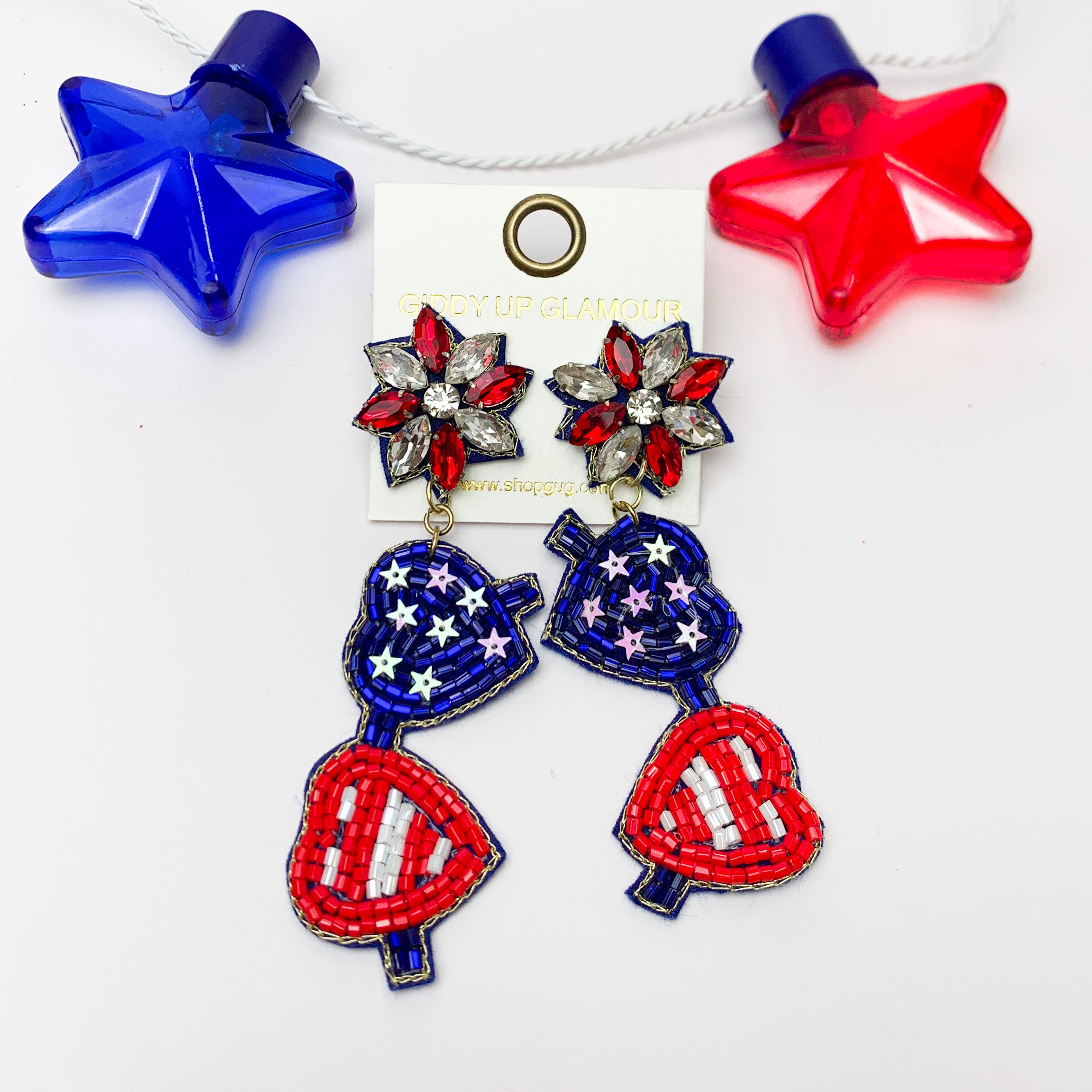 'Merica Stars and Stripes Sunglass Earrings. PIctured on a white background with a red and blue star above for decoration.