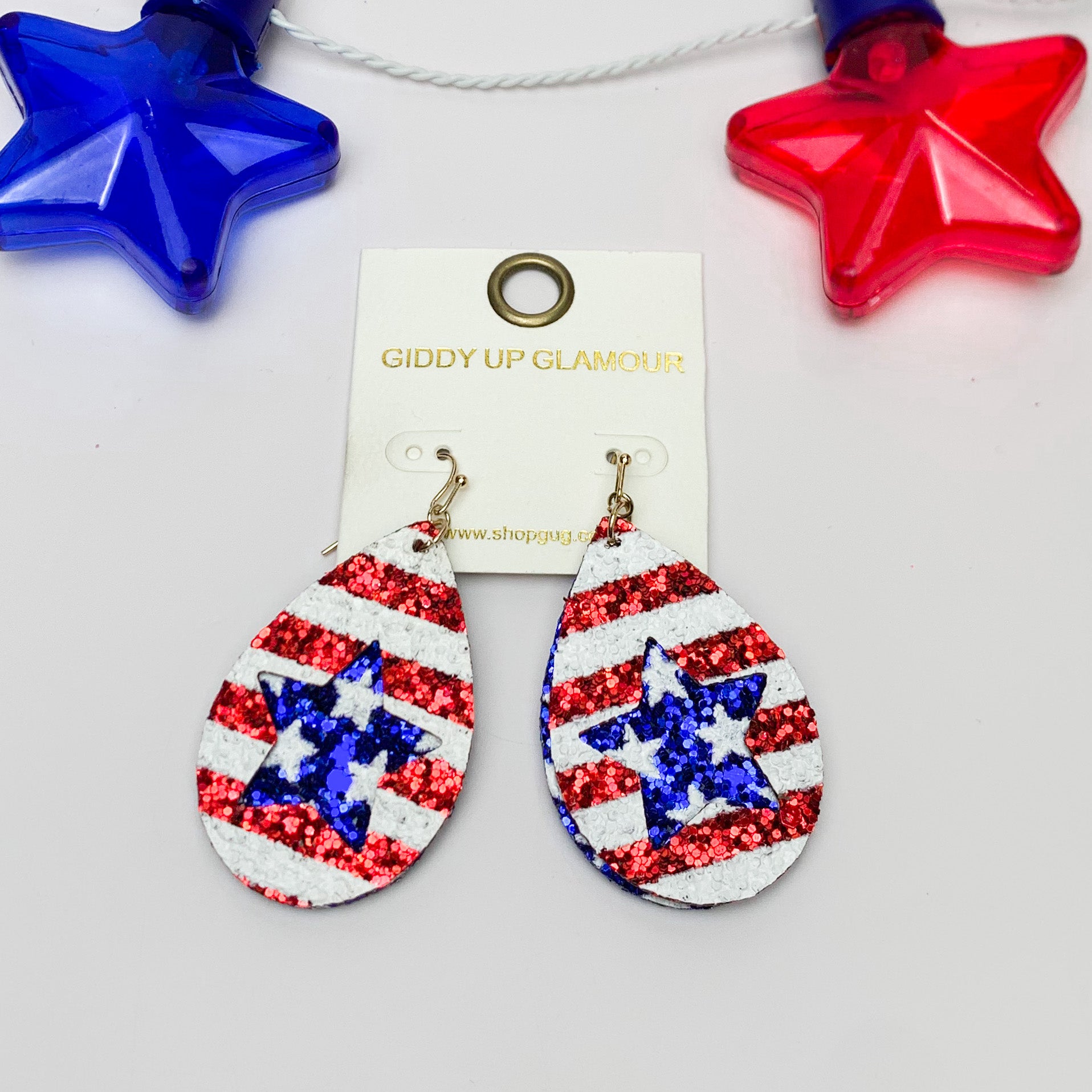 Star Cutout Glitter Patriotic Teardrop Earrings. Pictured on a white background with a red and blue star at the top for decoration.