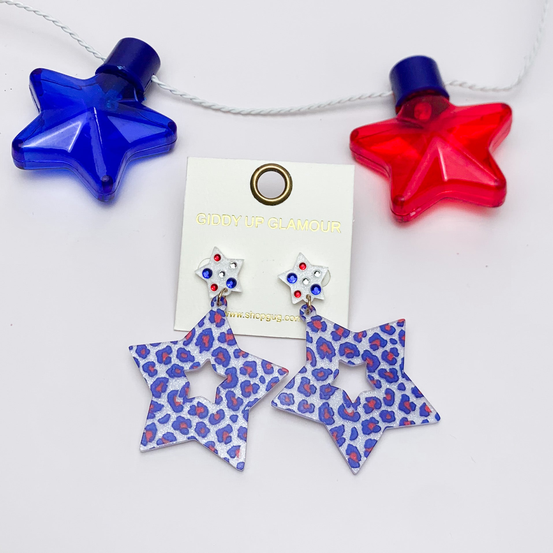 USA Fashionista Star Earrings in Red, White, and Blue. Pictured on a white background with a red and blue star above for decoration.